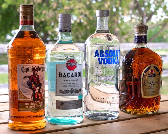 Bottles of assorted alcoholic beverages on a wooden surface