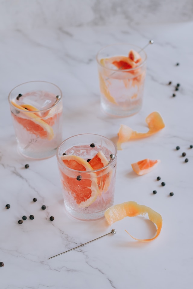 Clear liquid in clear glasses with wedges of grapefruit