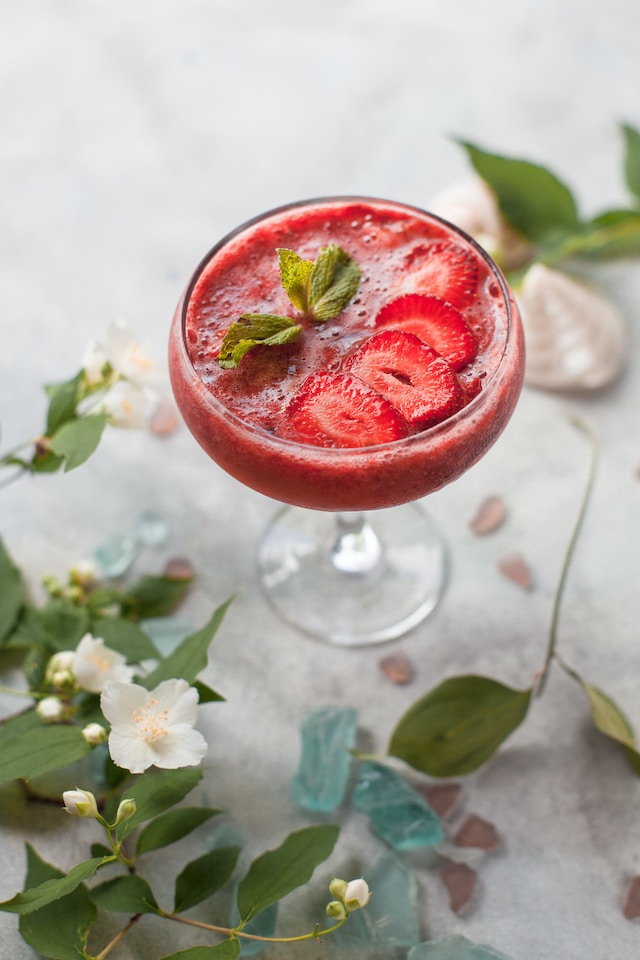 Strawberry drink garnished with fresh strawberry slices and mint leaves