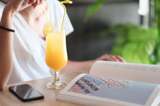 Person sipping on a drink while reading